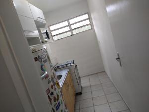 伯迪亚哥Bate & Volta - Apartamentos com 2 quartos próximo ao SESC Bertioga的带冰箱和窗户的小厨房