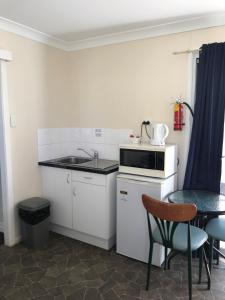温顿Australian Hotel Winton Cabins的一个带水槽和桌子的小厨房