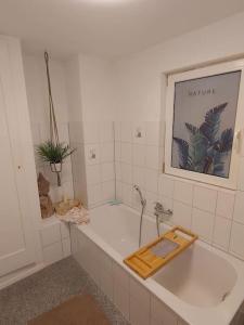 弗隆海姆Sabrina's Sandsteinhaus的带浴缸的浴室,墙上挂着一幅画