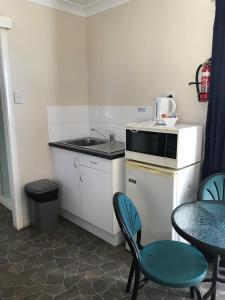 温顿Australian Hotel Winton Cabins的小厨房配有水槽和桌椅