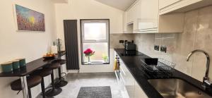 伦敦Beautiful London home sleeps 6, 2 minutes to metro的厨房配有黑色台面和窗户