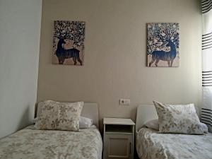 拉苏维亚ZUBICALM的墙上有两幅画作的房间的两张床