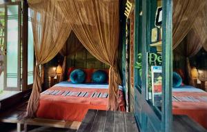 Pu LuongLua Pu Luong的一间卧室配有一张带红色床单和蓝色枕头的床。