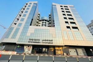 迪拜TIME Onyx Hotel Apartments的一座高大的建筑,两座高大的建筑