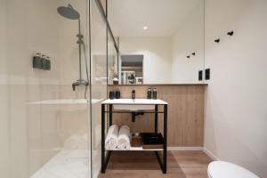 格拉纳达格拉纳达美利亚酒店的一间带玻璃淋浴和水槽的浴室