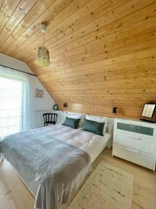 斯梅瑞克Kruszyna - domek z widokiem na połoniny的一间卧室设有一张带木制天花板的大床