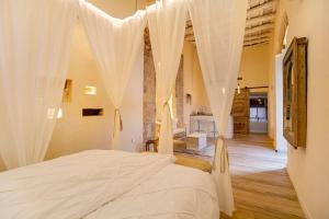 赫雷斯-德拉弗龙特拉Private Spa in Kangen House Jerez的一间卧室配有白色窗帘的床