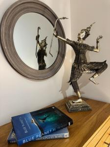 Earlham1A Priscilla Close的一本书和一张桌子上的雕像,上面有镜子