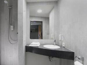舍讷费尔德柏林机场住宿加早餐酒店的一间带水槽和镜子的浴室