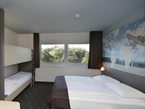 舍讷费尔德柏林机场住宿加早餐酒店的酒店客房设有两张床和窗户。