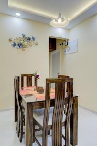 达波林Luxe 2BHK by Coral BnB with Pool access的一间带木桌和椅子的用餐室