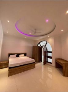 PrayagrajMauji's Villa Hotel & Guest House的一间卧室配有一张紫色天花板的床