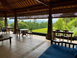姆杜克The Sangkih Villa Restaurant & Bar的一个带桌椅的庭院和大窗户。