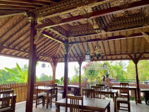 姆杜克The Sangkih Villa Restaurant & Bar的餐厅设有木桌和木椅