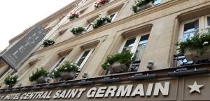 巴黎圣日耳曼中央酒店的带有盆栽植物和街道标志的建筑