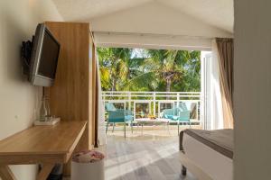 蒙舒瓦西Coral Azur Beach Resort Mont Choisy的酒店客房设有一张床和一个带椅子的阳台