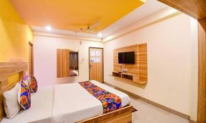 KhandagiriFabHotel Sai Jagannath Residency的一间酒店客房,配有一张床和一台电视