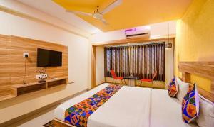 KhandagiriFabHotel Sai Jagannath Residency的一间卧室配有一张床和一台平面电视