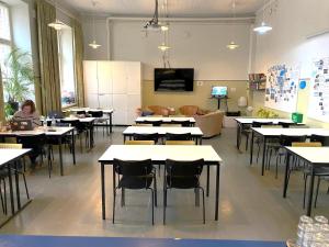 赫尔辛基芬兰堡酒店的教室里摆放着桌椅,还有一位女士坐在桌子上