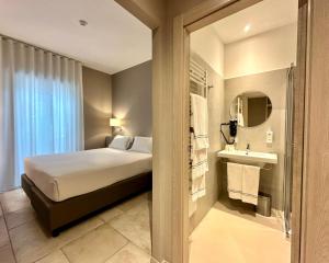 焦维纳佐里瓦德尔索尔酒店的一间卧室配有一张床,浴室设有水槽