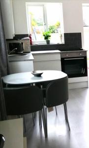 基德明斯特Self contained annexe的厨房配有桌子和2把黑色椅子