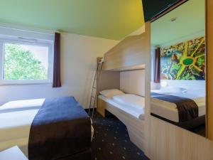 多特蒙德B&B HOTEL Dortmund-Messe的一间卧室配有两张床和一张双层床。