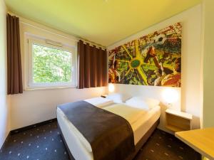 多特蒙德B&B HOTEL Dortmund-Messe的一间卧室配有一张壁画床