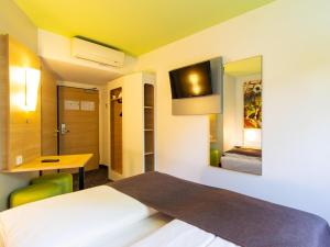 多特蒙德B&B HOTEL Dortmund-Messe的客房设有1张床、1张办公桌和1台电视。