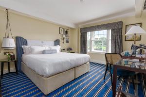 亨利昂泰晤士The Relais Henley的酒店客房设有一张大床和一张书桌。