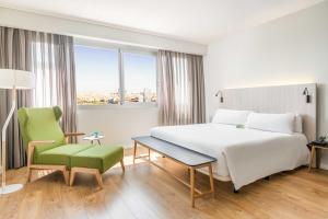 马德里ARTIEM Madrid的酒店客房设有一张大床和一张绿色椅子。