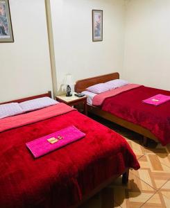 利马KORICANCHA的客房内的两张床和粉红色的毛巾