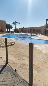 拉特吉塔Apartamento El Faro, Sotavento, playa la tejíta的游泳池前面设有长凳