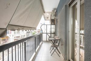 雅典Ioannis Cozy Apartment 500 meters from Acropolis museum的阳台配有桌椅。