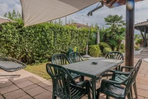维佐拉提契诺[Ca' Roby] Malpensa Airport relax - Free Wifi的庭院里配有桌椅和遮阳伞