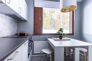 SuomutunturiHoliday Apartment Usva Studio II的厨房配有白色的桌子和窗户。