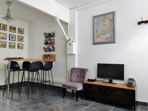 博韦LA PETITE MAISON的配有桌椅和电视的客房
