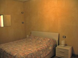 马罗内Chalet della Rota的一间小卧室,配有床和床头柜
