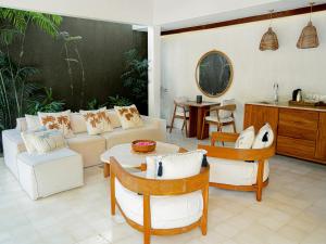 吉利特拉旺安Cocana Resort Gili Trawangan的客厅配有沙发和桌椅