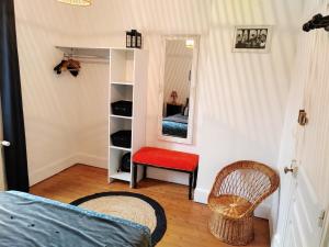 博韦LA PETITE MAISON的一间卧室配有一张床、镜子和椅子