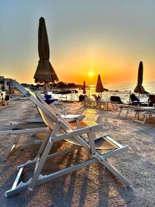 焦维纳佐里瓦德尔索尔酒店的海滩上的一组躺椅和遮阳伞