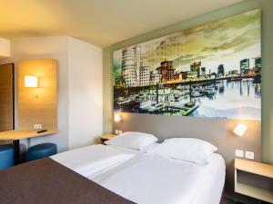 杜塞尔多夫B&B Hotel Düsseldorf City-Süd的酒店客房设有一张床,墙上挂有绘画作品