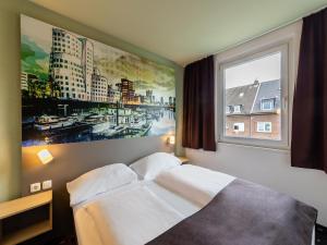 杜塞尔多夫B&B Hotel Düsseldorf City-Süd的一张位于带大窗户的房间内的床铺