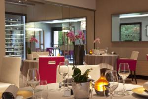 Saint-Ouen-les-Vignes罗比尼尔餐厅及水疗酒店 的用餐室配有桌椅和酒杯