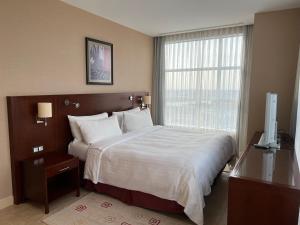 阿特劳Atyrau Executive Apartments的一间卧室设有一张大床和一个窗户。