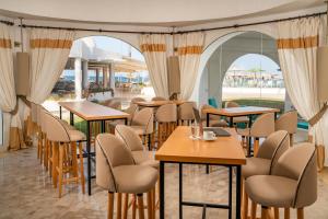 莫纳斯提尔Monarque Club Rivage - VV的餐厅设有桌椅和窗户。