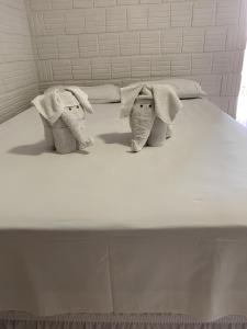 博尼图查莱公寓酒店的两头塞满大象的睡床上