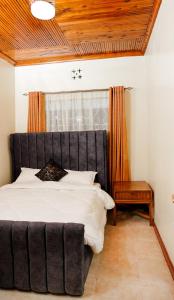 奈瓦沙Naivasha TownHouse的一间卧室设有一张大床和一个窗户。