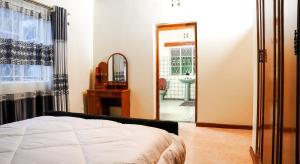 奈瓦沙Naivasha TownHouse的一间带床和镜子的卧室以及一间浴室