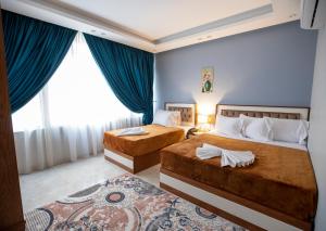开罗El Shams Plaza Hotel的蓝色墙壁客房的两张床