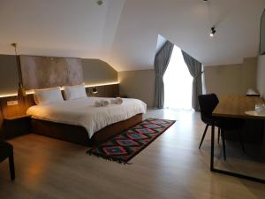 戈里察MIK Hotel Korce的酒店客房配有一张床铺、一张桌子和一张书桌。